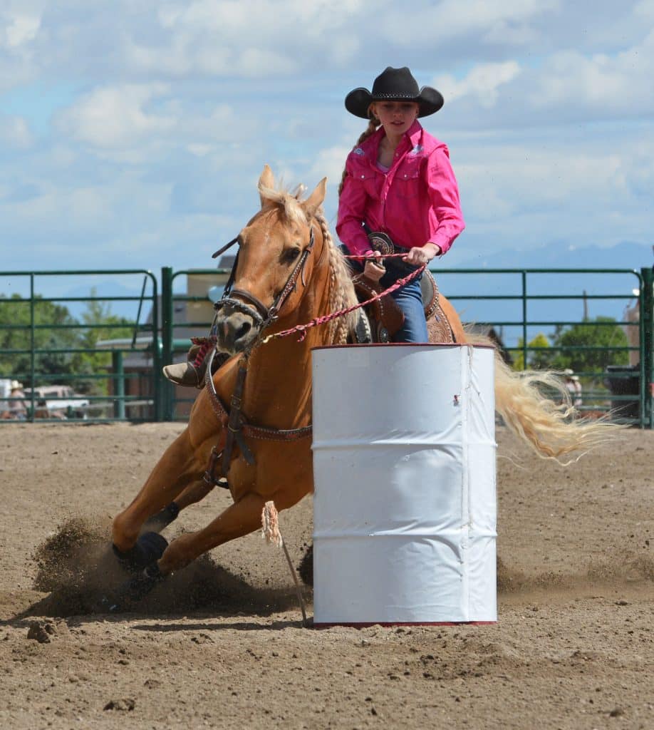 Athletic horse turning around a barrel with a rider